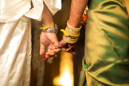 Close up of groom holding brides hand in south Indian wedding ceremony