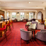 The bar area with cosy armchairs, fireplace and flat-screen TV in the lounge at Mercure Leeds Parkway Hotel