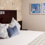 Privilege bedroom at Mercure Leeds Parkway Hotel, blue velvet cushion detail with blue artwork on the wall