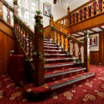 The staircase in the lobby at Mercure Leeds Parkway Hotel dressed for a wedding with ivy and tea light holders